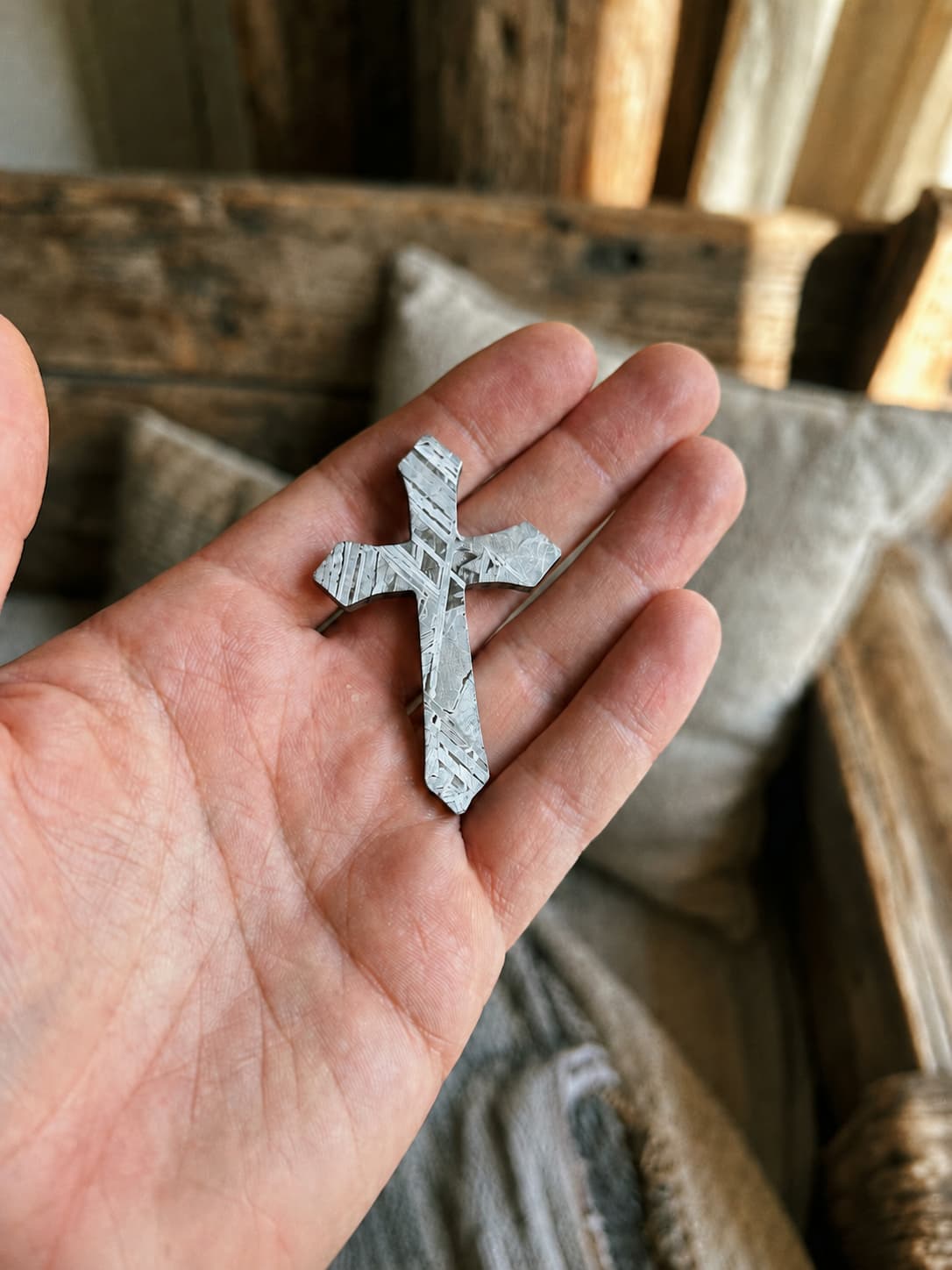 The Oath Cross held in hand, showing scale and surface pattern
